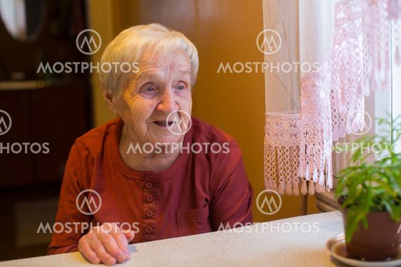 An elderly woman sitting at the table.