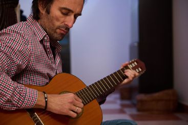 Man playing acoustic guitar in casual indoor atmosphere