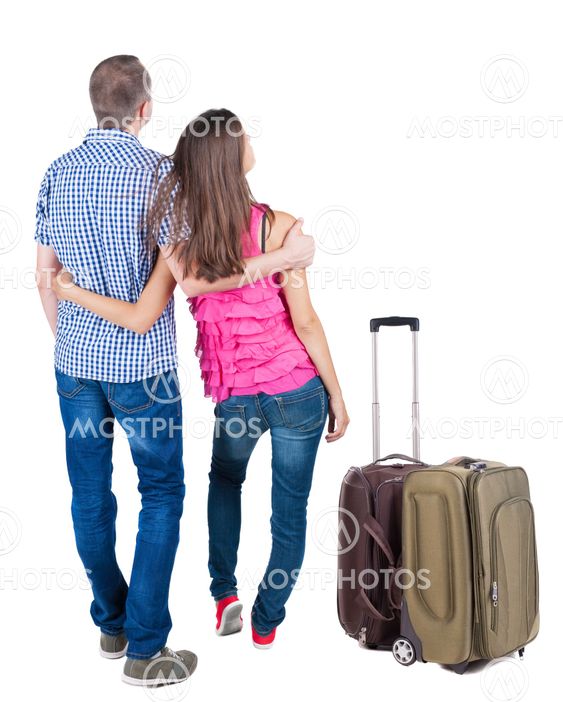 Back view of young couple traveling with suitcas .