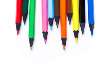 Colorful art supplies arranged neatly on a white...