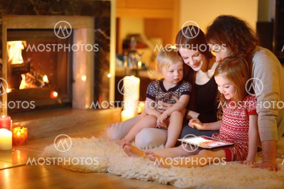 Happy family using a tablet pc by a fireplace