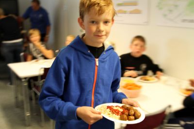 Pojke med tallrik i matsal