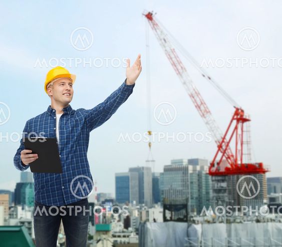 smiling male builder in helmet with clipboard