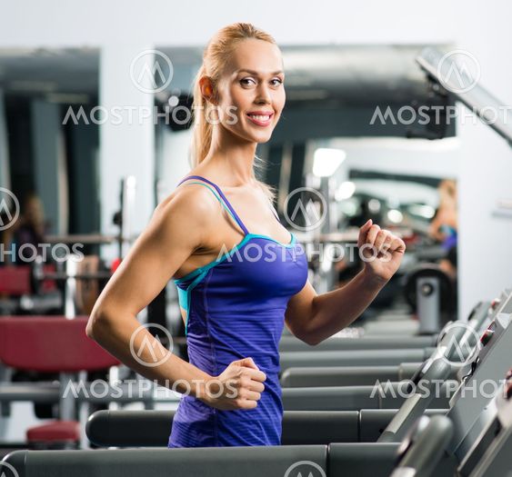 attractive young woman runs on a treadmill
