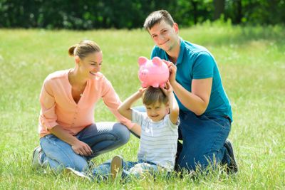 Parents With Their Son Holding Piggy Bank