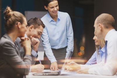 smiling female boss talking to business team