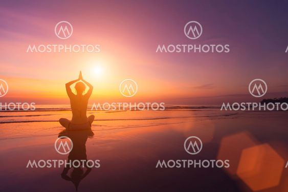 Silhouette of a girl in a pose of yoga on a beautiful...