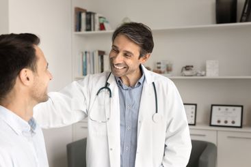 Positive successful male Latin doctor man touching...