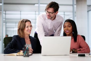 Collaborating Business Team Smiling Together On Laptop