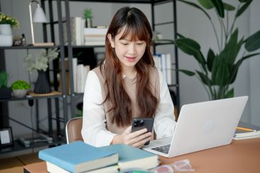 Asian woman using laptop to study student engaged in...
