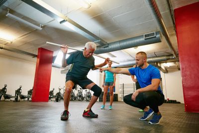 Legs apart...a senior man doing pvc pipe exercises with...