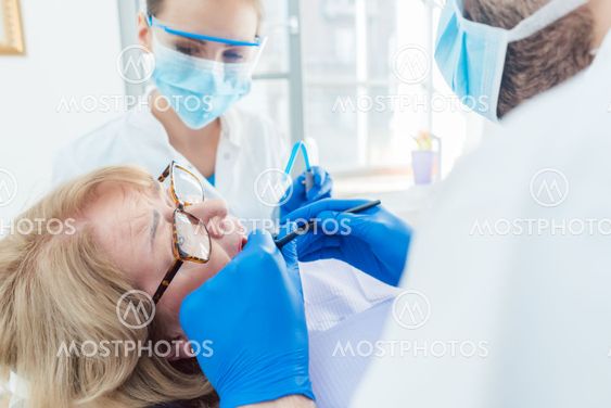 Dentist during treatment of a senior patient