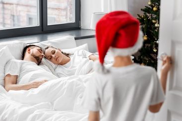 child looking at sleeping parents on christmas