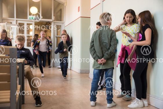 barn springer genom skolkorridor