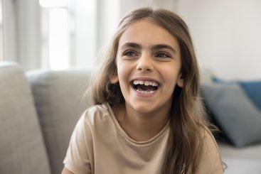 Head shot close up portrait of laughing little girl