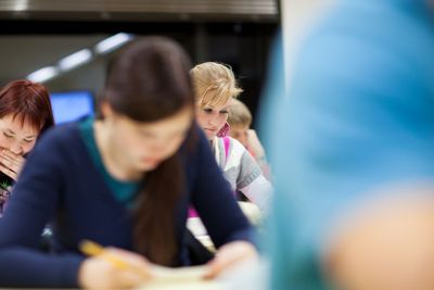 pretty, female college student sitting in a classroom...