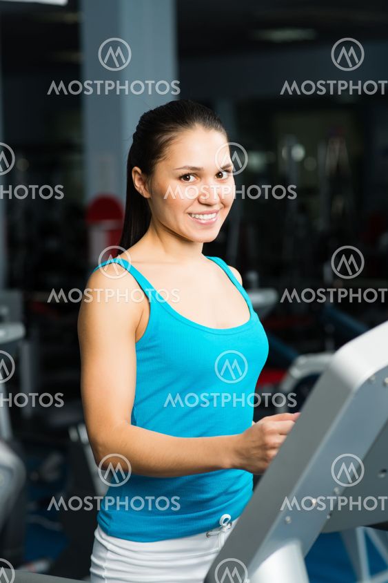 attractive young woman runs on a treadmill