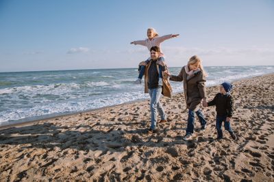 family on seashore in autumn
