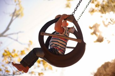 Tree, tyre swing and child in park with fun, outdoor...