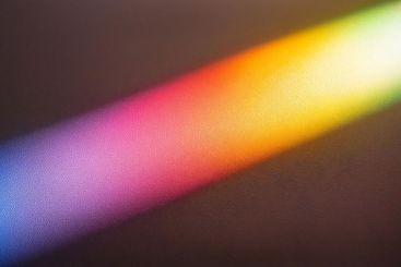 Diagonal beam of light creating a rainbow on a textured...