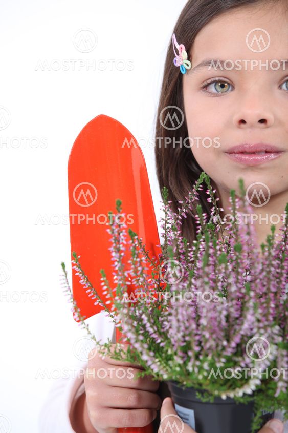 little girl with shy smile gardening
