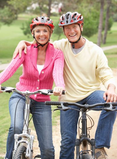 Senior couple riding bicycle in park
