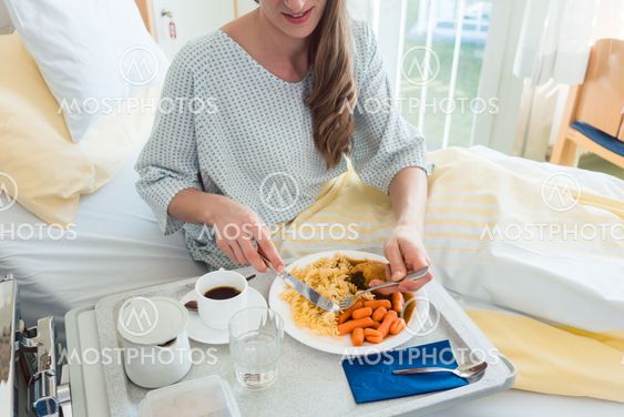 Patient in hospital lying in bed eating meal