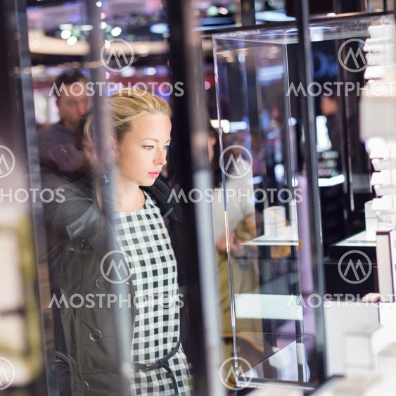 Beautiful woman standing in front of showcase.