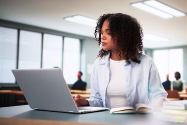 Student Girl In Classroom Using Laptop