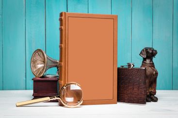 Vintage objects and a blank book displayed on a wooden...