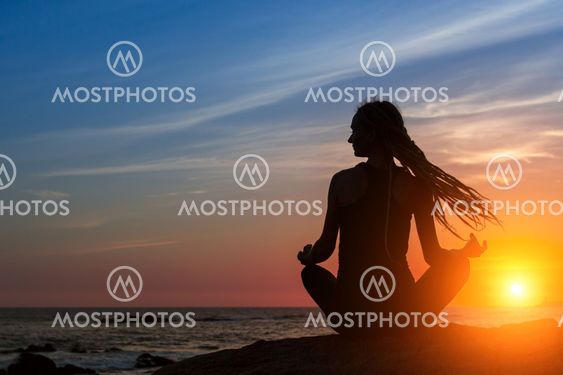 Silhouette woman yoga on the beach at amazing sunset. Meditation, fitness and healthy lifestyle.