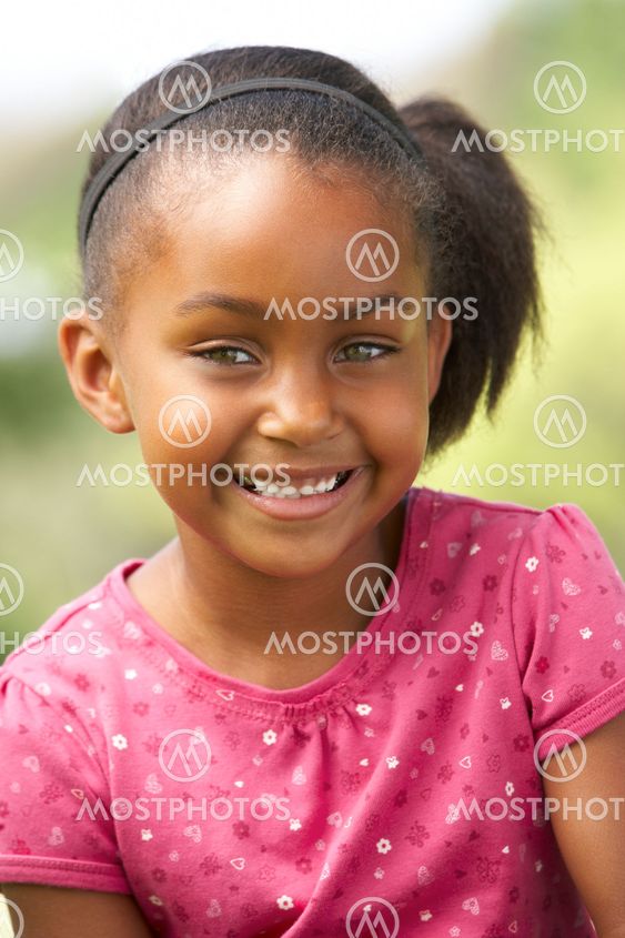 Portrait Of Young Girl Sitting In Park