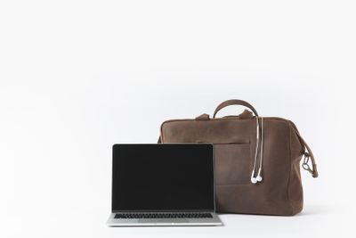 close up view of laptop with blank screen and stylish bag...