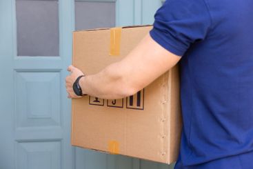 Hands of male courier holding large cardboard box