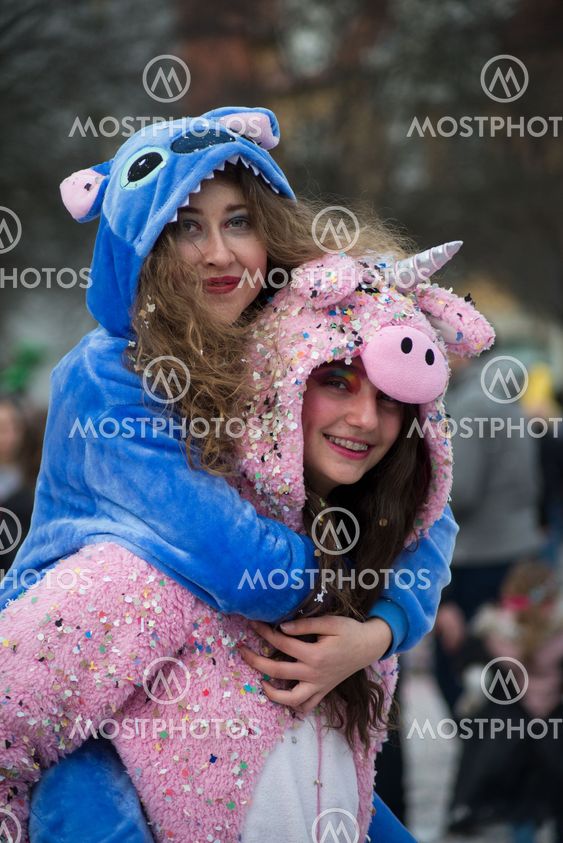 o girls wearing a unicorn costume smiling in the street...
