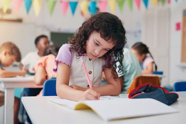 Notebook, education and writing with girl in classroom...