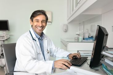 Cheerful successful male Latin physician doctor working...