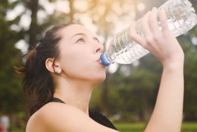 Portrait of sportswoman drinking water after workout