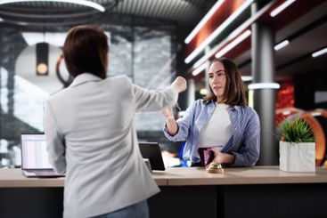 Professional Woman Discussing Reservation with Hotel...