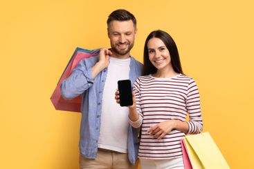 Couple enjoying a shopping day together while expressing...