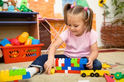 Little girl is playing with building bricks