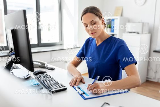doctor or nurse with clipboard working at hospital