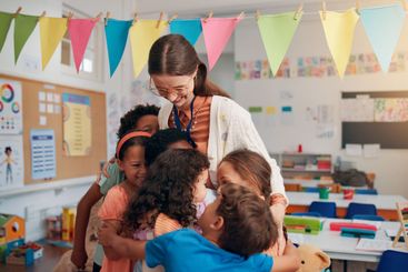 Happy, care and children hugging teacher in classroom...