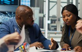 Factory engineers look at assembly lines designs, working...