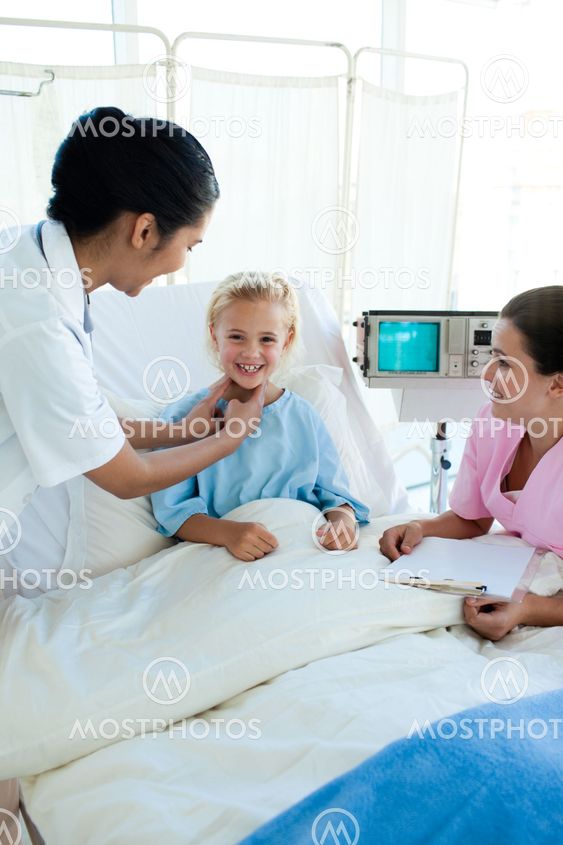 Attractive doctor examining a little female patient