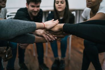 Team of work showing unity with their hand together.