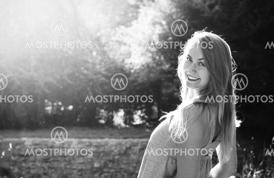 Smiling blond young woman in a park