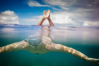 Young male snorkeler divingin the sea