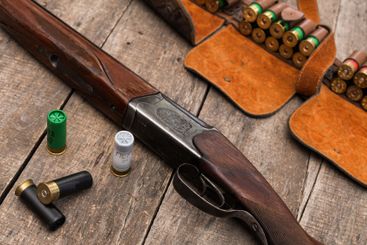Vintage shotgun resting on a wooden surface with...