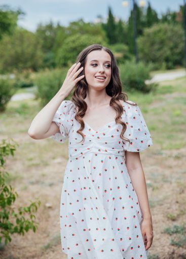 Beautiful slim brunette woman in summer white dress...